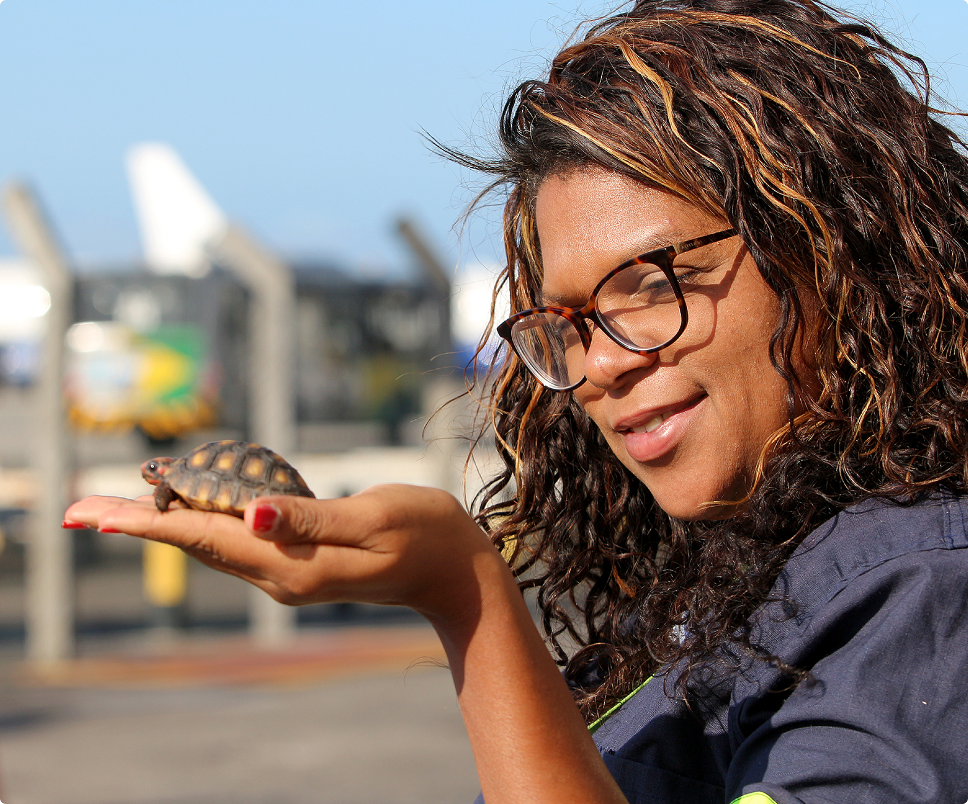 Salariée de VINCI Airports tenant une tortue dans la main